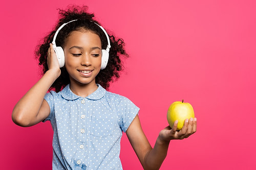 Smiling,Curly,African,American,Kid,In,Headphones,Holding,Apple,Isolated